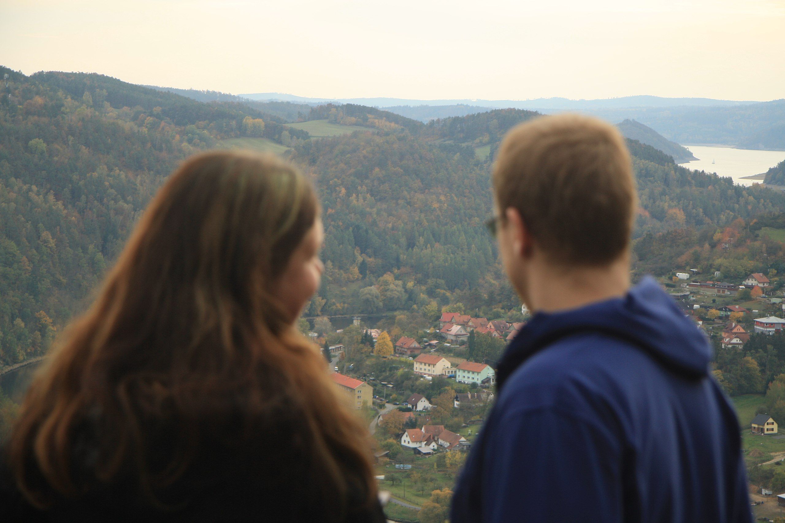 couple looking out over scenic view with hills in distance