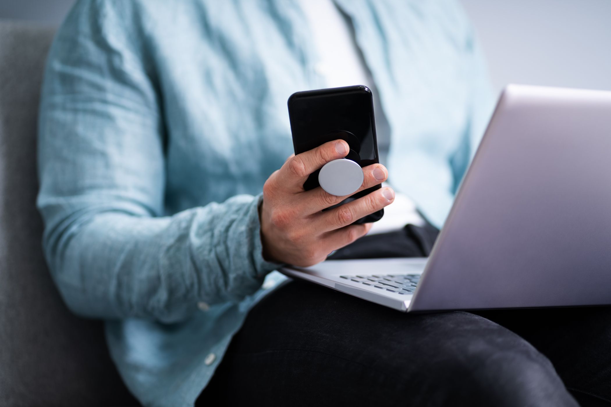 A man holding a phone with the help of a pop socket